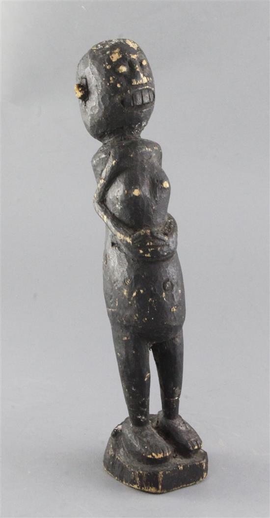 An African stained carved figure of a woman, with inset ears, 34cm
